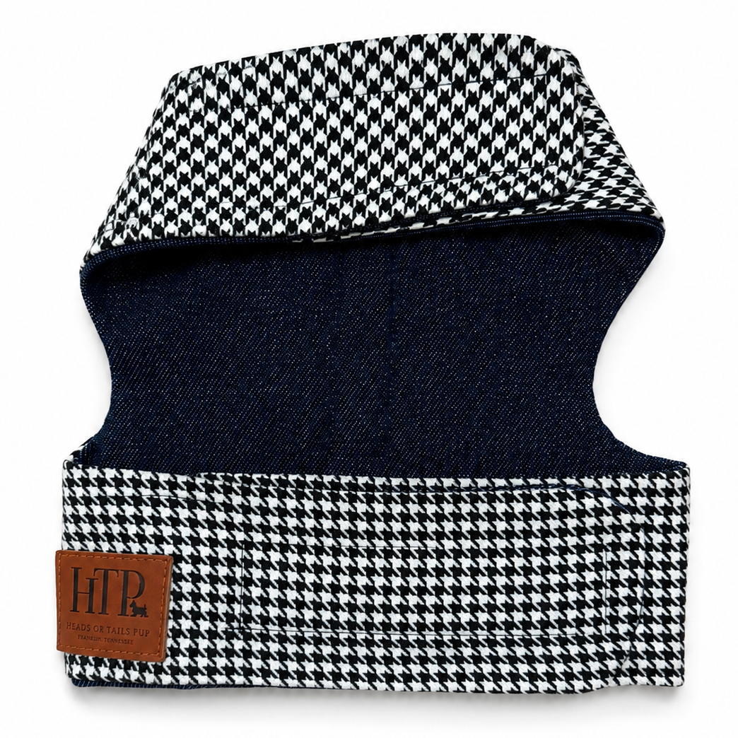 A pet harness with a black and white houndstooth pattern on the outer fabric and a dark navy blue interior lining. A brown leather brand patch on the lower left reads 'HTP'.