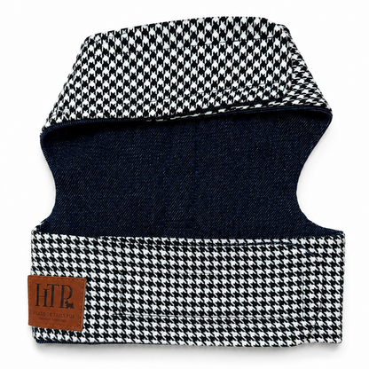 A pet harness with a black and white houndstooth pattern on the outer fabric and a dark navy blue interior lining. A brown leather brand patch on the lower left reads 'HTP'.