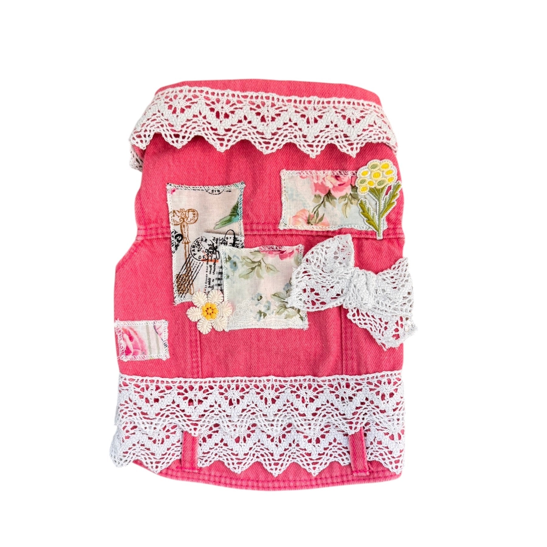 Pink dog vest with floral patterns and lace details on a white background