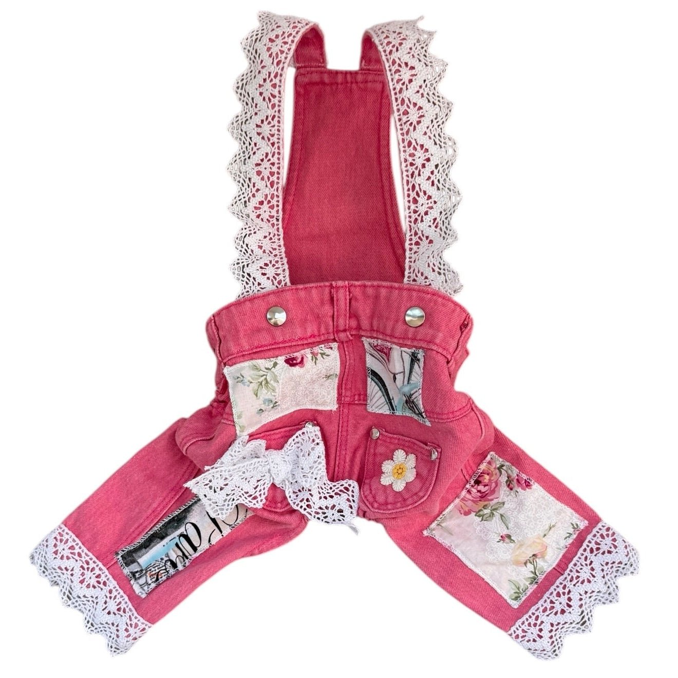 Pink denim overalls with lace trim and floral patterns on a white background