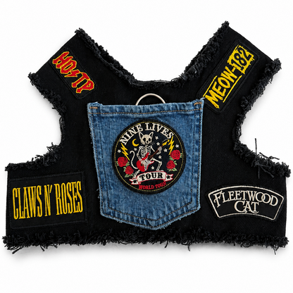A black frayed biker harness featuring multiple band and rock-themed patches with Cat puns including Fleetwood Cat, Nine Lives Tour, Claws 'N' Roses, and Meow 182, arranged flat against a white background.