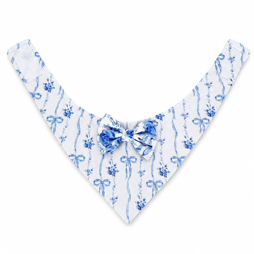 A white triangular pet bandana with a blue watercolor-style ribbon and floral pattern, featuring a matching blue bow at the center collar, displayed on a clean white background.