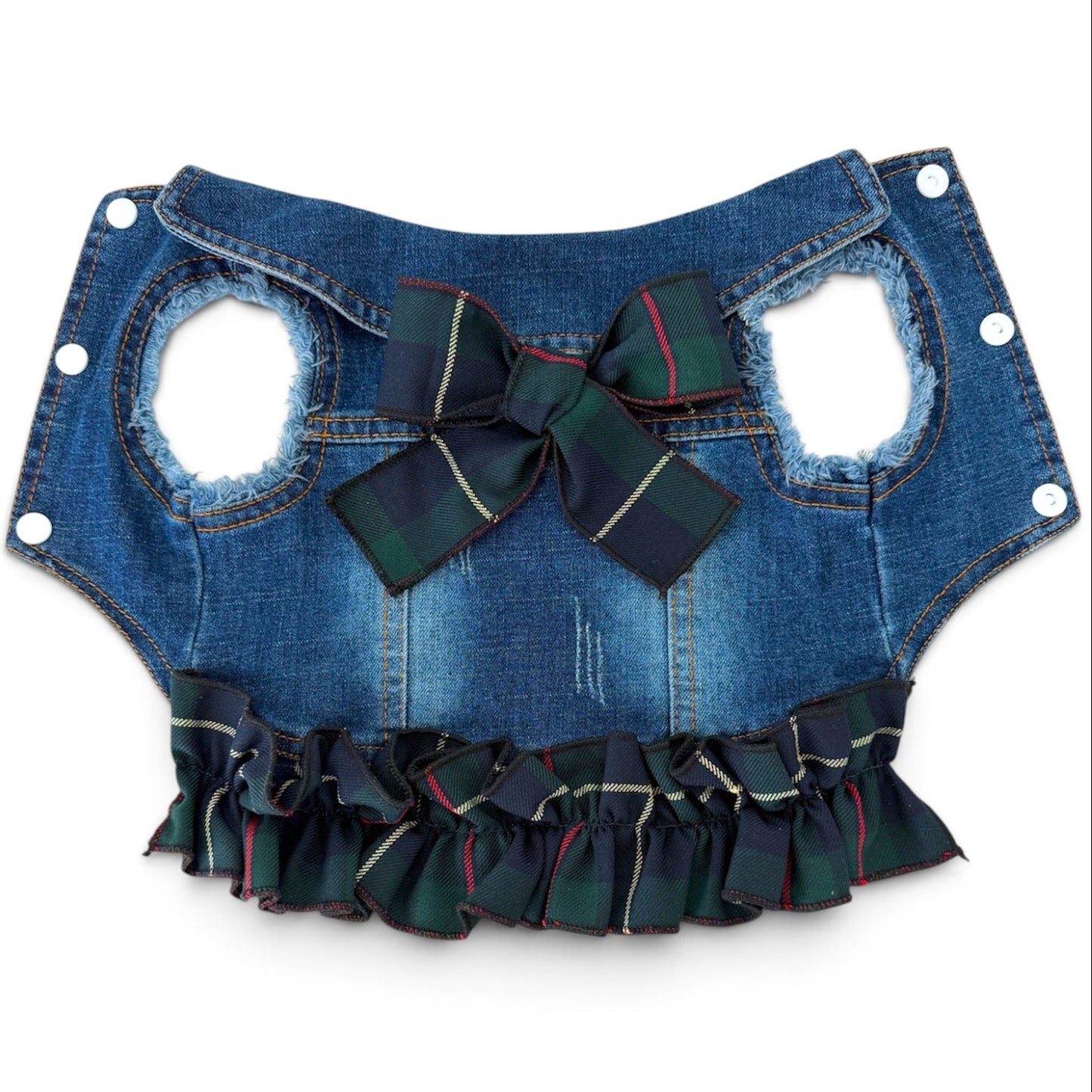 A blue denim pet vest with a large green plaid bow at the center, and a matching ruffled trim along the bottom edge, shown against a plain white background.